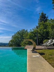 a swimming pool with a sculpture next to the water at Villa Regina in Sanxenxo