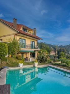 a house with a swimming pool in front of a house at Villa Regina in Sanxenxo