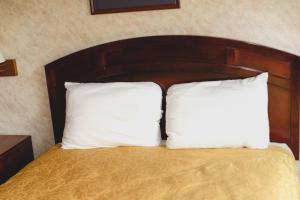 two white pillows sitting on a bed in a room at Colfax Inn By Marifah in Colfax