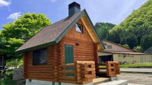 a log cabin with a pitched roof and a green door at New Kurumi Land - Vacation STAY 41992v 
