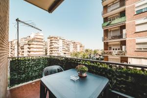 a blue table and chairs on a balcony with buildings at Tibur Domus B&B in Rome