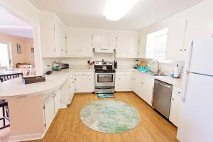 a kitchen with white cabinets and a rug on the floor at Lorraine's Beach Cottage in Kure Beach +42 photos