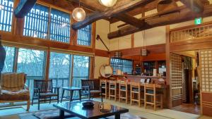 una gran sala de estar con techos y ventanas de madera. en Forest Villa Shionine Kogen - Vacation STAY 45539v en Shiojiri