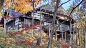 a large wooden house in the middle of trees at Forest Villa Shionine Kogen - Vacation STAY 45539v in Shiojiri