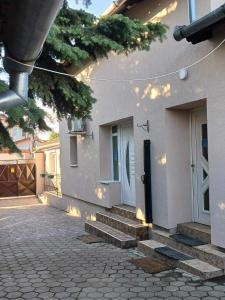 a white house with stairs leading to a door at Mega Apartment in Subotica