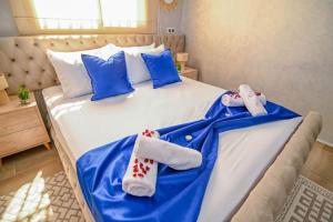 Una cama con sábanas azules y blancas y toallas. en The Skyline Stay, en Marrakech