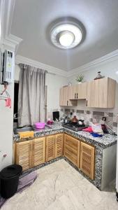 a kitchen with wooden cabinets and a counter top at شقة للعائلات مفروشة in Taroudant