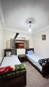 a room with two beds and a tv in it at شقة للعائلات مفروشة in Taroudant