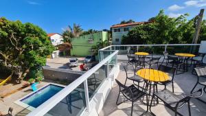 a balcony with a table and chairs and a pool at Porto Vila by AFT in Porto De Galinhas