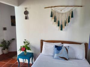 a bedroom with a bed and a blue table at Chalé Flor do Ser in Canoa Quebrada