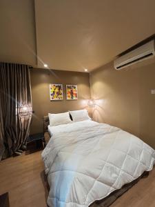 a bedroom with a large white bed with two lamps at Mindyourbusiness villa in Abuja