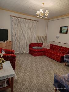 BadacsonyörsにあるPanoráma Holiday Homeのリビングルーム(赤いソファ、テレビ付)