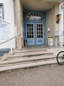 a blue door of a building with a bike parked in front at Ferienwohnung 304 am Kasinopark in Georgsmarienhütte