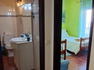 a bathroom with a sink and a room with a bed at Casa Jasmim - charming houses - Alojamento Local - perto Zambujeira do Mar in São Teotónio +54 photos