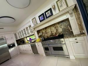 a kitchen with white cabinets and a stove top oven at Vila Manor in Midrakh ‘Oz +13 photos