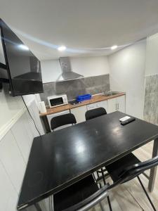 a kitchen with a black table and chairs at Estudios sol in Madrid