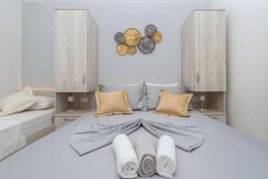 1 dormitorio con 1 cama con toallas y donuts en la pared en Apartmants Šestić en Tučepi