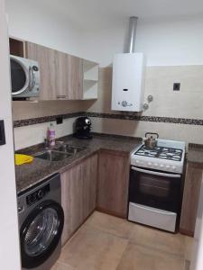 eine Küche mit Waschmaschine in der Unterkunft Amplio Dpto con 2 dormitorios primer piso independiente con asador in San Francisco