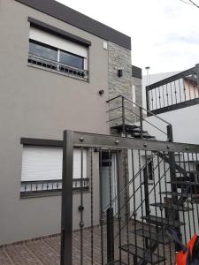 ein weißes Gebäude mit einer Treppe und einem Fenster in der Unterkunft Amplio Dpto con 2 dormitorios primer piso independiente con asador in San Francisco