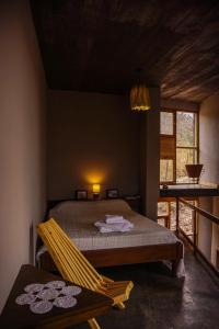 a bedroom with a bed and a chair in a room at Cueva Ancestral --Experiencia entre los cerros-- in Coronel Moldes