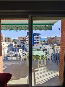 a patio with a table and chairs on a balcony at Apartamento sencillo Cerca del mar . in Cullera