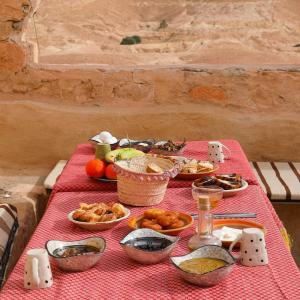 a table with food on a red table cloth at Gite Douiret in Ad Duwayrāt +21 photos