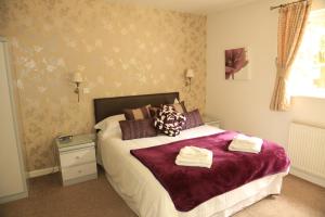 a bedroom with a bed with two towels on it at Rooms & Camping Pods at Colliford Tavern in Bodmin