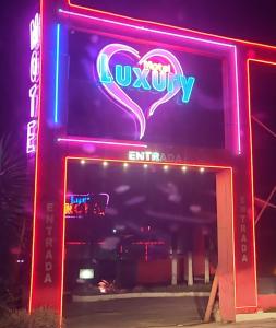 a neon sign for a nightclub with a heart at Luxury Motel in Sorocaba