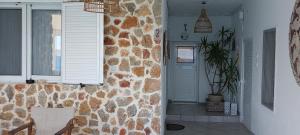 a hallway with a stone wall with a chair and a window at Sunrise Apartments in Livadia +37 photos