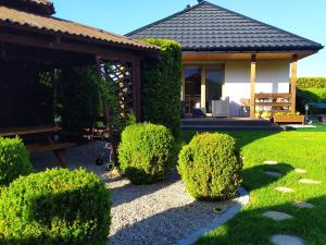 a garden with a gazebo and some bushes at Domki Zorza in Darłowo
