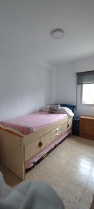 a bedroom with a bed in a room with a window at Apartamento sencillo Cerca del mar . in Cullera