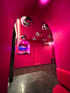 a pink room with pink lights and a mirror at Andar de Cima Suítes in Sao Paulo