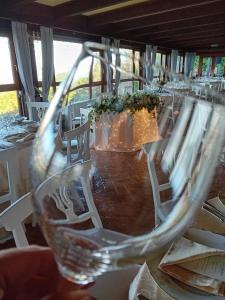 un tavolo con sedie bianche e un bicchiere di vino di Borgo Di Celle a Città di Castello