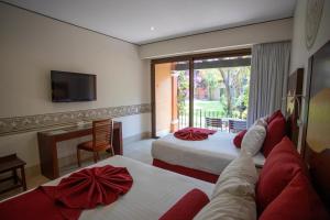 a hotel room with two beds and a television at Hosteria Las Quintas Hotel Restaurante Bar in Cuernavaca