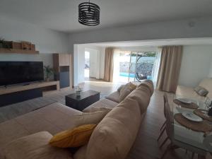 a living room with a couch and a tv at Casa Reina Tauro with private pool in La Playa de Tauro
