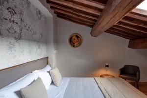 ein Schlafzimmer mit einem weißen Bett und einem Stuhl in der Unterkunft Borgo Di Celle in Città di Castello