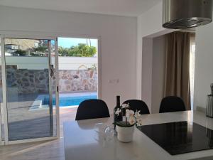 a dining room with a table and chairs and a pool at Casa Reina Tauro with private pool in La Playa de Tauro
