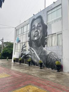 Friendly Apartment Tamayo في ليما: لوحة جدارية كبيرة لامرأة على جانب المبنى