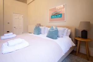 a bedroom with a white bed with blue pillows at The Ballroom - Huge Apartment in Lichfield City Centre in Lichfield +36 photos