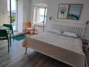 una camera con un grande letto e una sedia di Apartments & Rooms Dinko a Valun