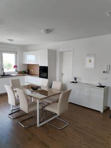 a kitchen and dining room with a table and chairs at Apartman Petra in Brodarica