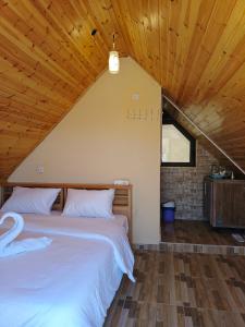 uma cama num quarto com tecto em madeira em Dana luxury huts em Dana
