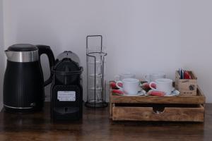 una macchinetta del caffè e tazze su un tavolo di Vatican 23 Museum Suites a Roma