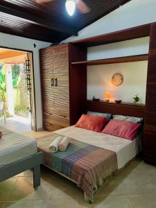 a bedroom with a large bed with red pillows on it at Tropical Hostel in Pipa