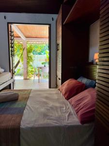a bedroom with a large bed and a patio at Tropical Hostel in Pipa