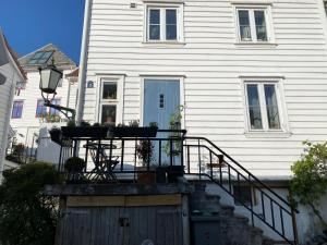une maison avec une porte en bois et une terrasse couverte dans l'établissement Renovated apartment from 1780, located in heritage site (Skuteviken), à Bergen