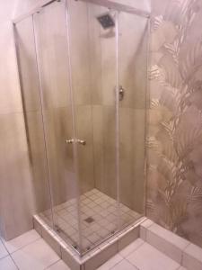 a shower with a glass door in a bathroom at 4 bedroom house, Amanzimtoti DBN in Amanzimtoti