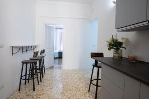 una cucina con un bancone e sgabelli in una stanza di Vatican 23 Museum Suites a Roma