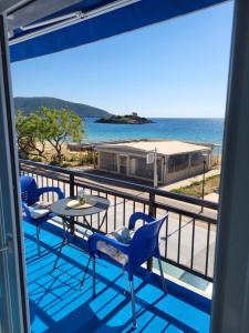 a balcony with a table and chairs and the ocean at Upper Deck Apt. in Nea Peramos