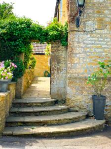 una entrada a un edificio con escaleras y flores en The Crown & Victoria Inn, en Tintinhull